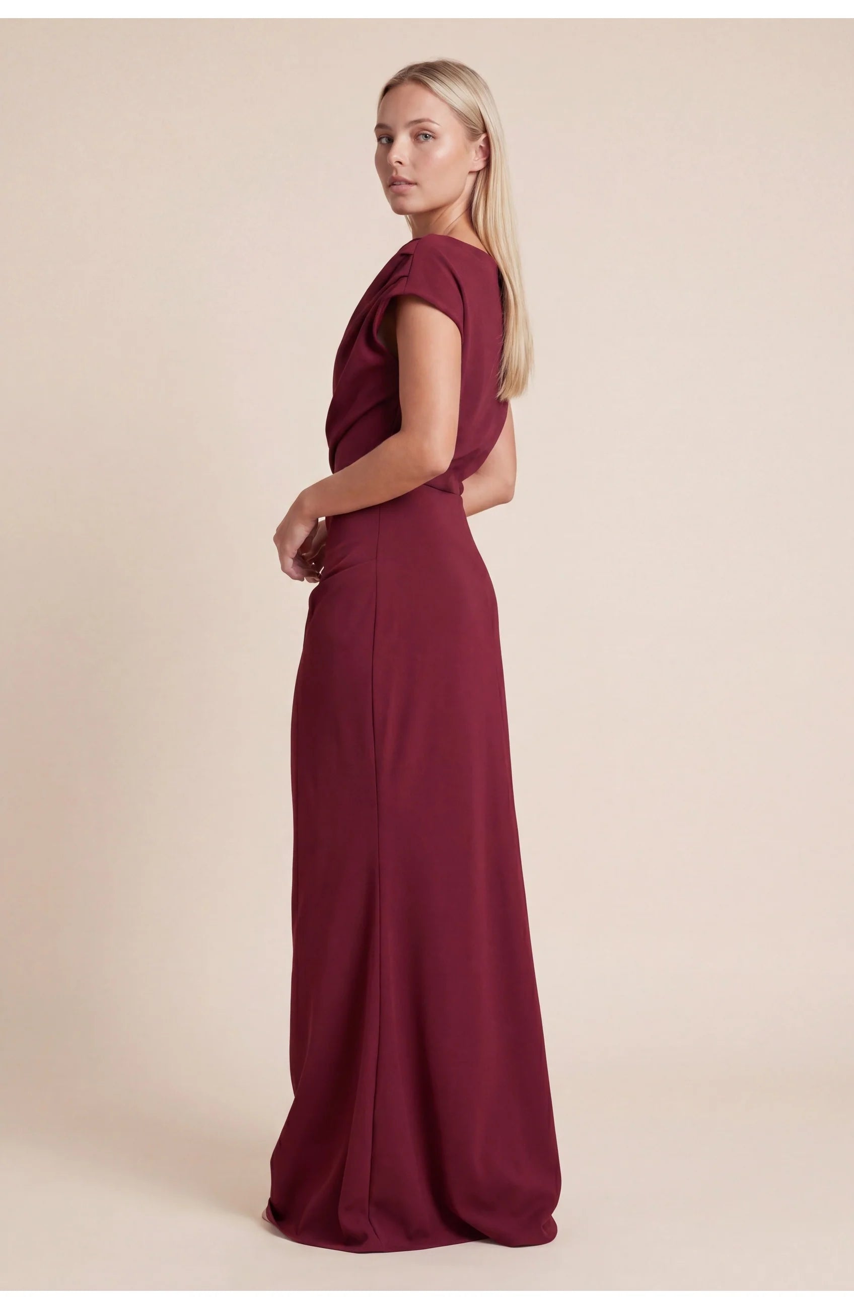 Zijaanzicht van gedrapeerde off-shoulder maxi jurk met asymmetrische halslijn en vloeiende rok