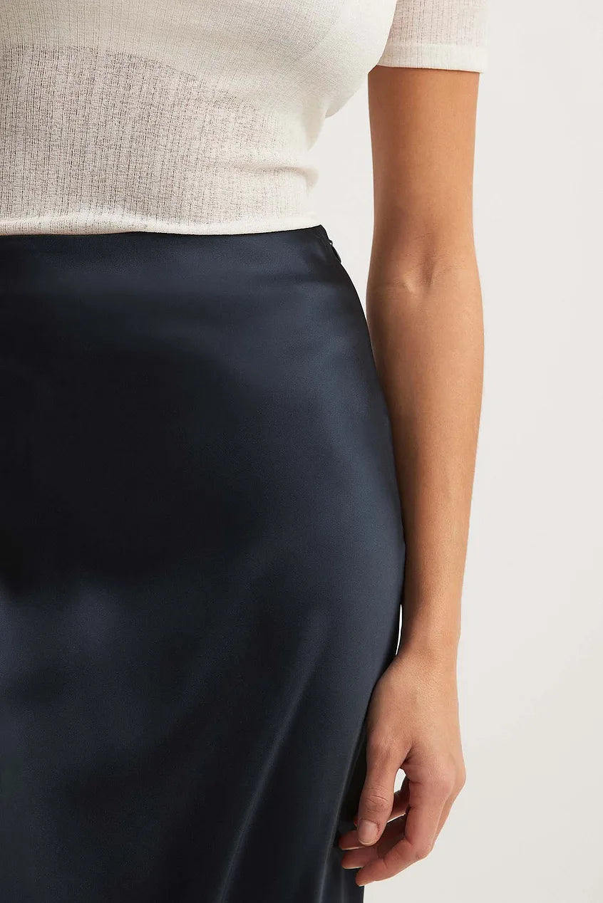 Vrouw draagt satijnen rok met hakken voor een verfijnde, moeiteloze look