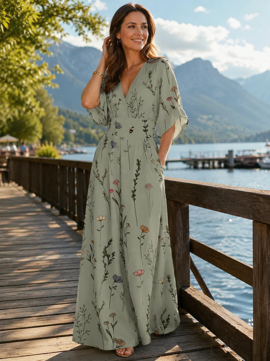 Vrouw draagt mintgroene maxi jurk met botanische bloemenprint en V-hals tijdens zomerse wandeling langs meer