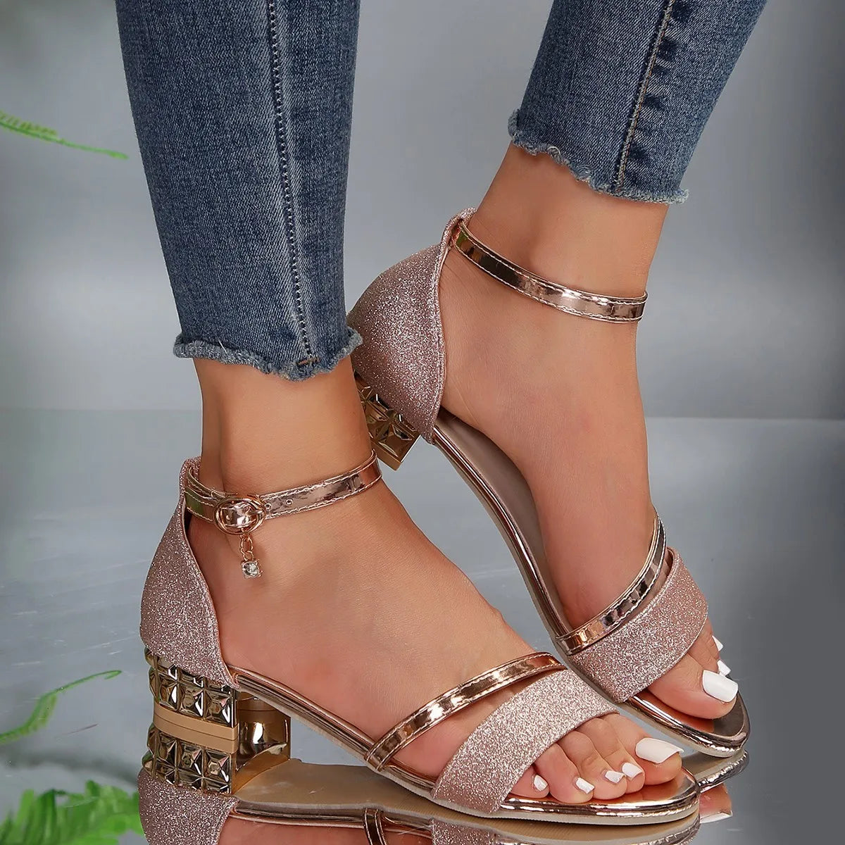 Detail van blokhak sandalen met zwarte bandjes en gouden metallic accenten voor vrouwen
