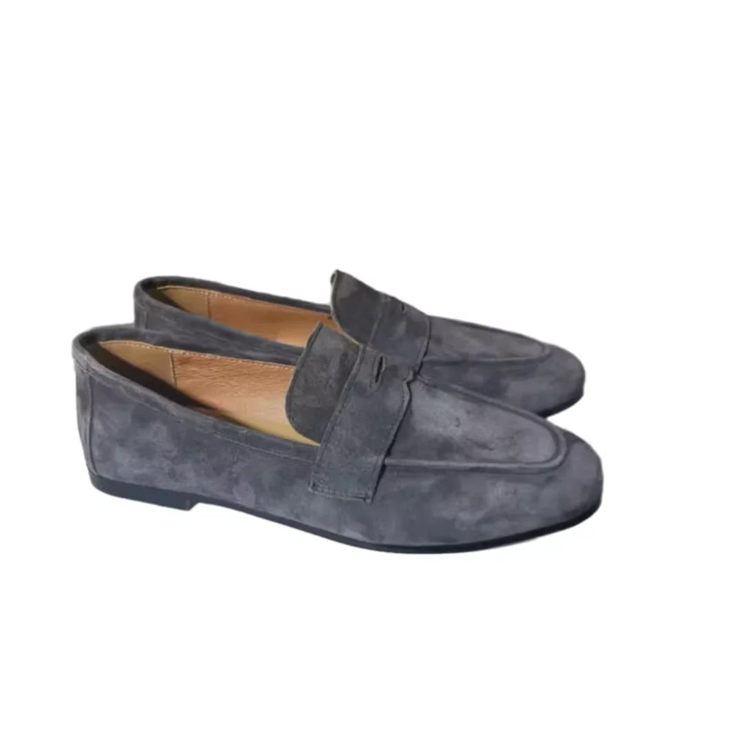 Detail van platte loafers met gevouwen band en gladde afwerking voor moderne uitstraling