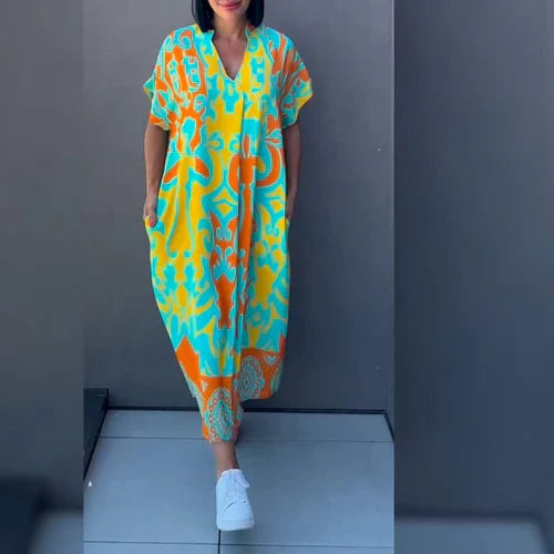 Losse kaftan jurk in midi lengte met vloeiende stof en felle kleuren voor vakantie