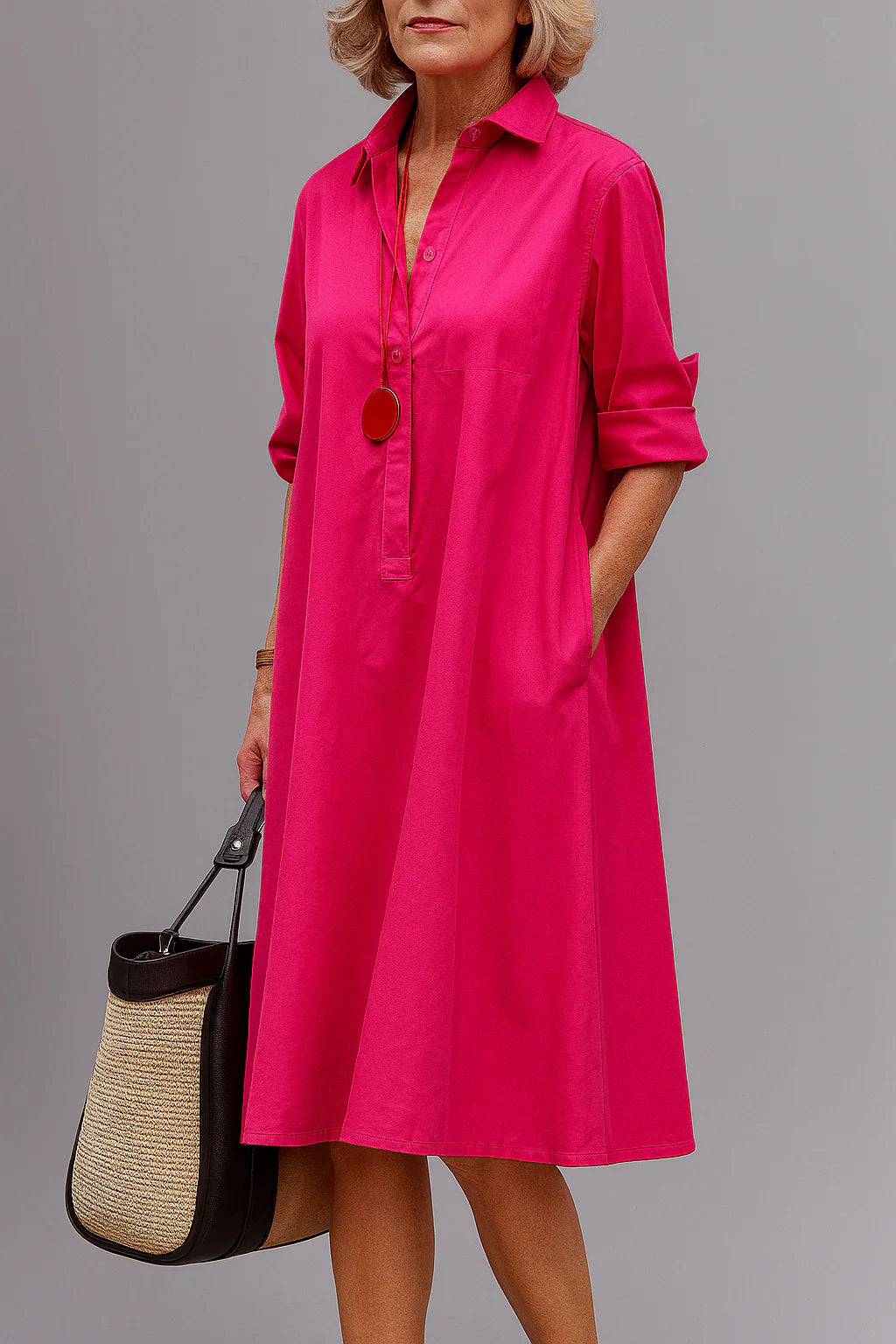 Roze midi jurk met kraag en oprolbare mouwen gedragen door model met rieten tas