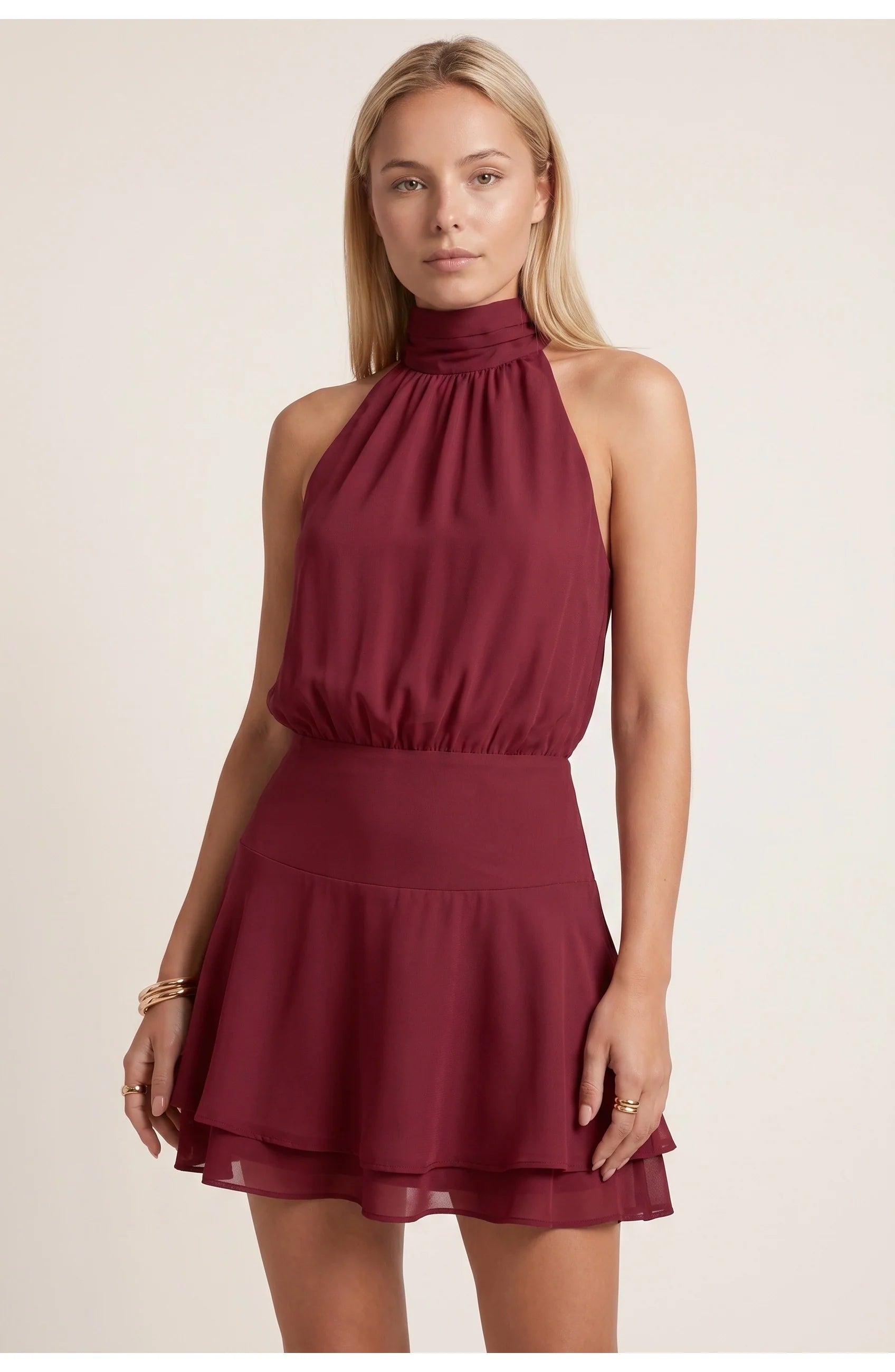 Model draagt halternek mini jurk met hoge sandalen voor een glamoureuze feestlook