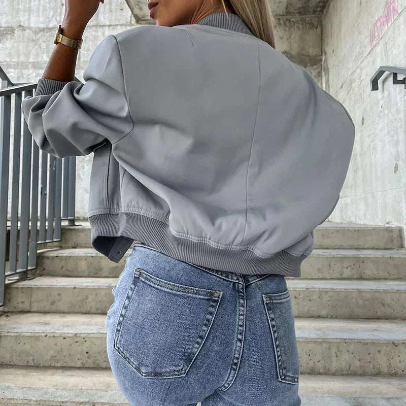 Dames bomber jas gedragen met witte top en jeans voor casual weekendstijl