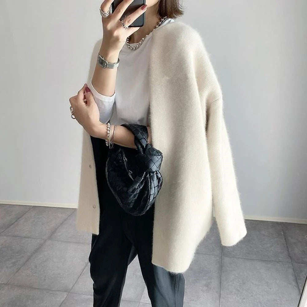 Dames oversized vest ribgebreid in crème met lange mouwen en open voorkant gedragen met zwarte broek