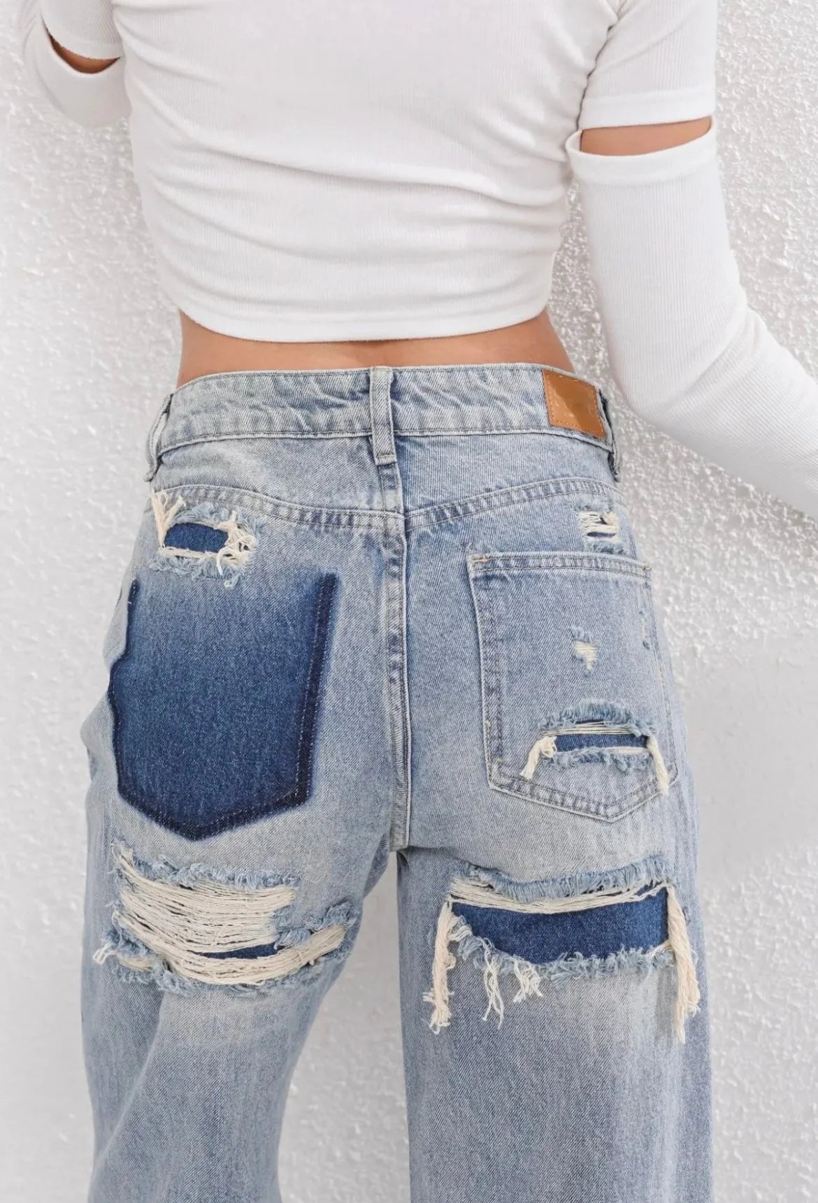 Close-up van ripped details op achterzijde van dames straight leg jeans