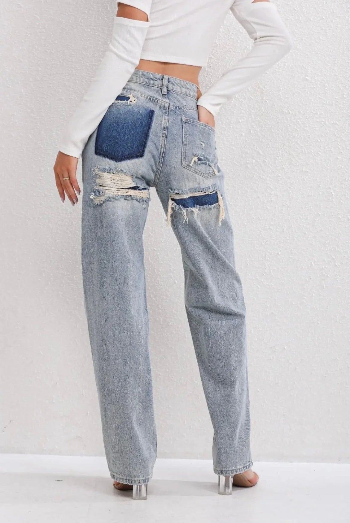 Detail van contrasterende achterzak op lichtblauwe straight leg jeans