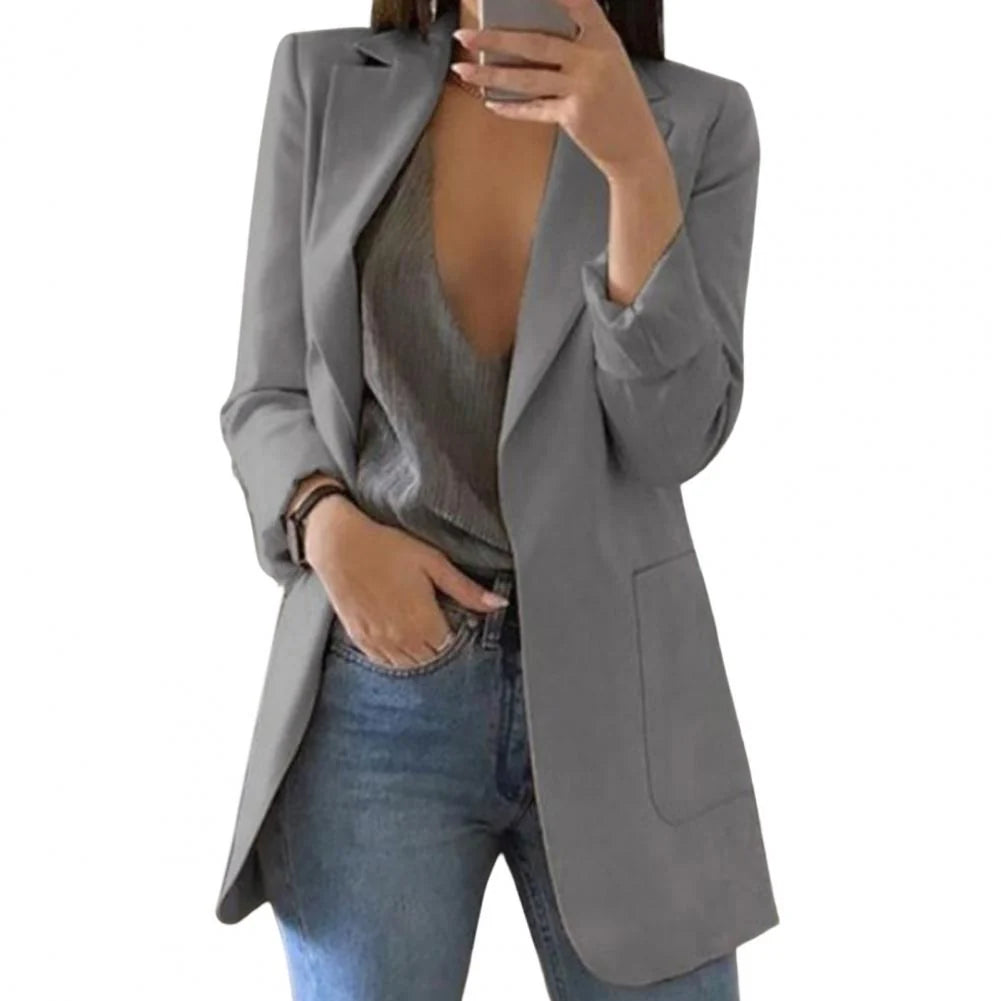 Zijaanzicht van de lange blazer die de getailleerde pasvorm en verlengde lengte toont