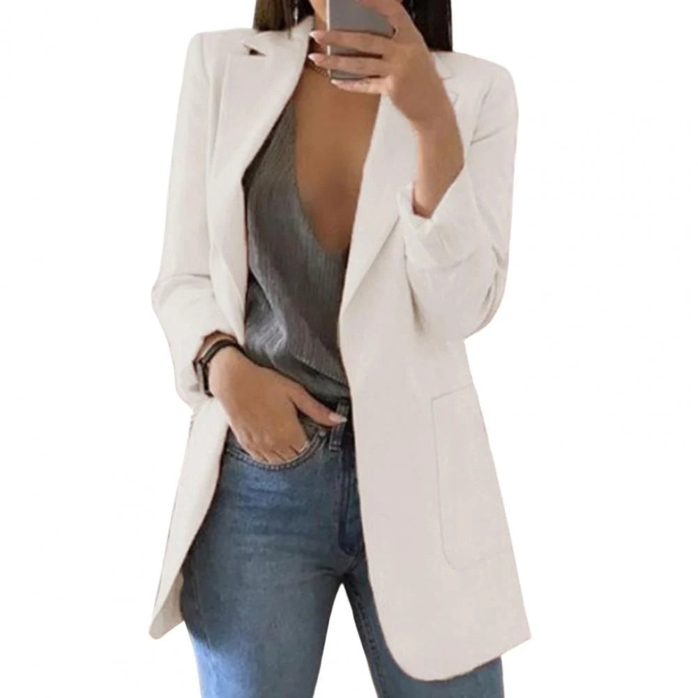 Vrouw draagt de blazer open over een top, wat de relaxte pasvorm laat zien
