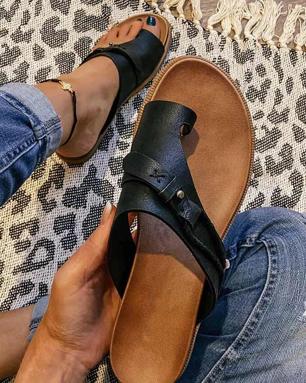 Bovenaanzicht van dames leren slippers met teensluiting en gespsluiting op natuurlijke achtergrond