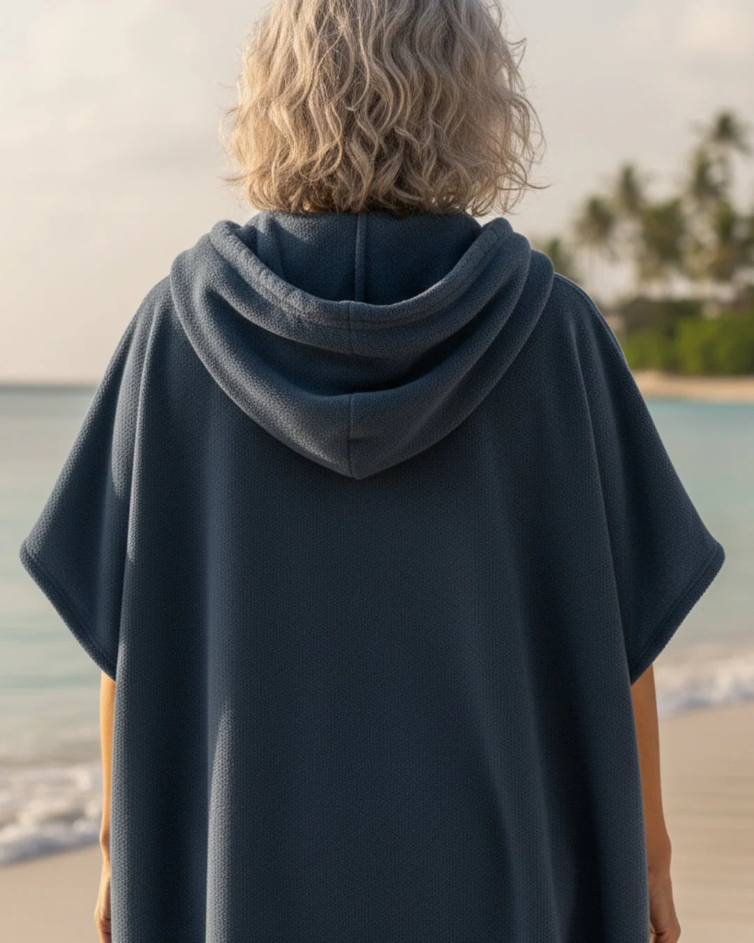 Zijaanzicht van poncho jurk met korte mouwen en knielengte snit voor strandkleding