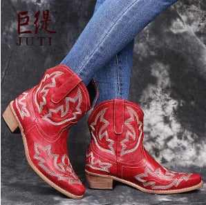 Close-up van geborduurde leren cowboylaarzen met decoratieve stiksels en natuurlijke leerstructuur