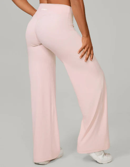 Dames flared stretchbroek met hoge taille en wijdlopende pijpen in zachte lichtroze kleur gedragen door model