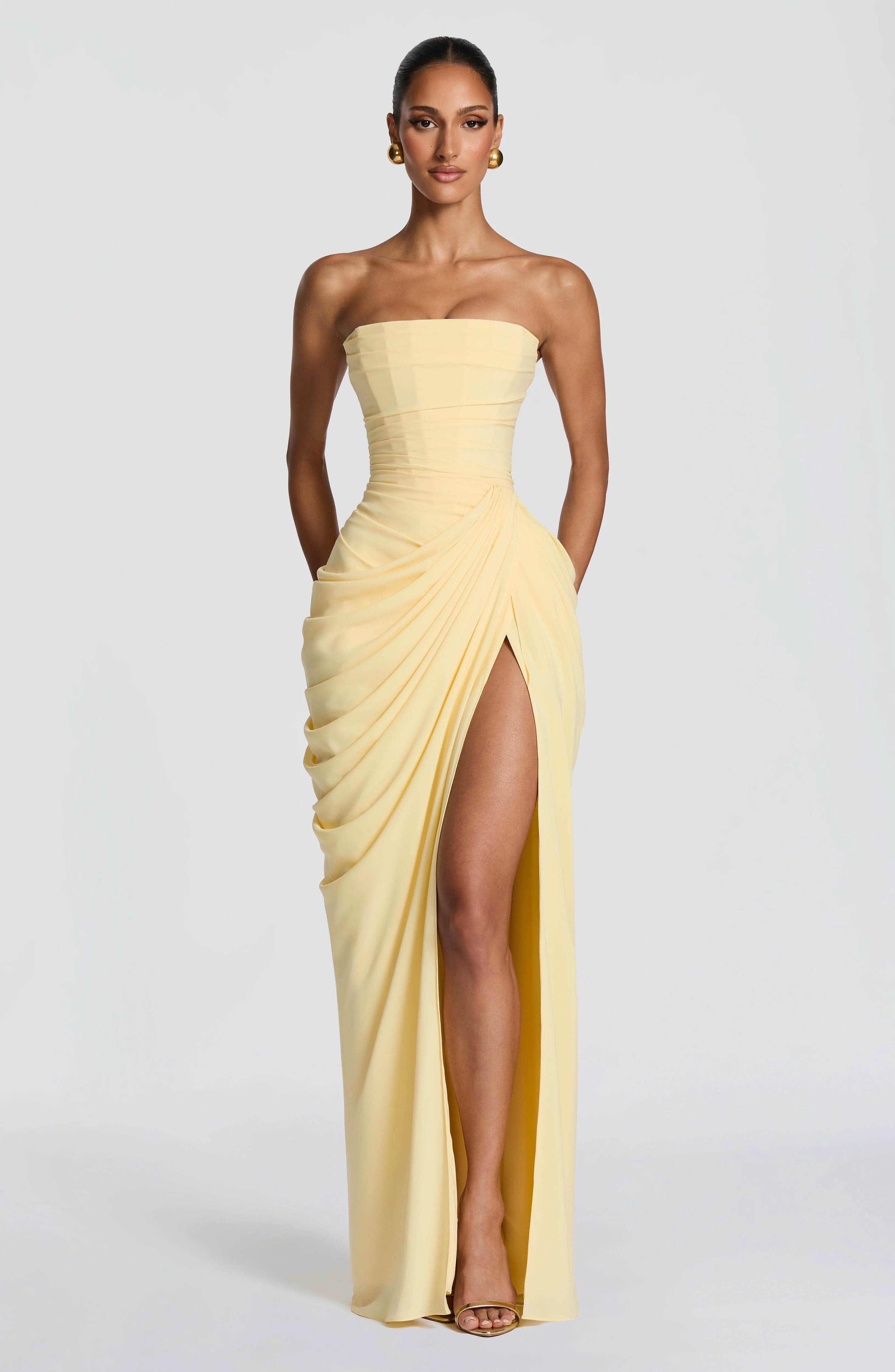 Zijaanzicht van strapless avondjurk met asymmetrische drapering en hoge beensplit voor elegante uitstraling