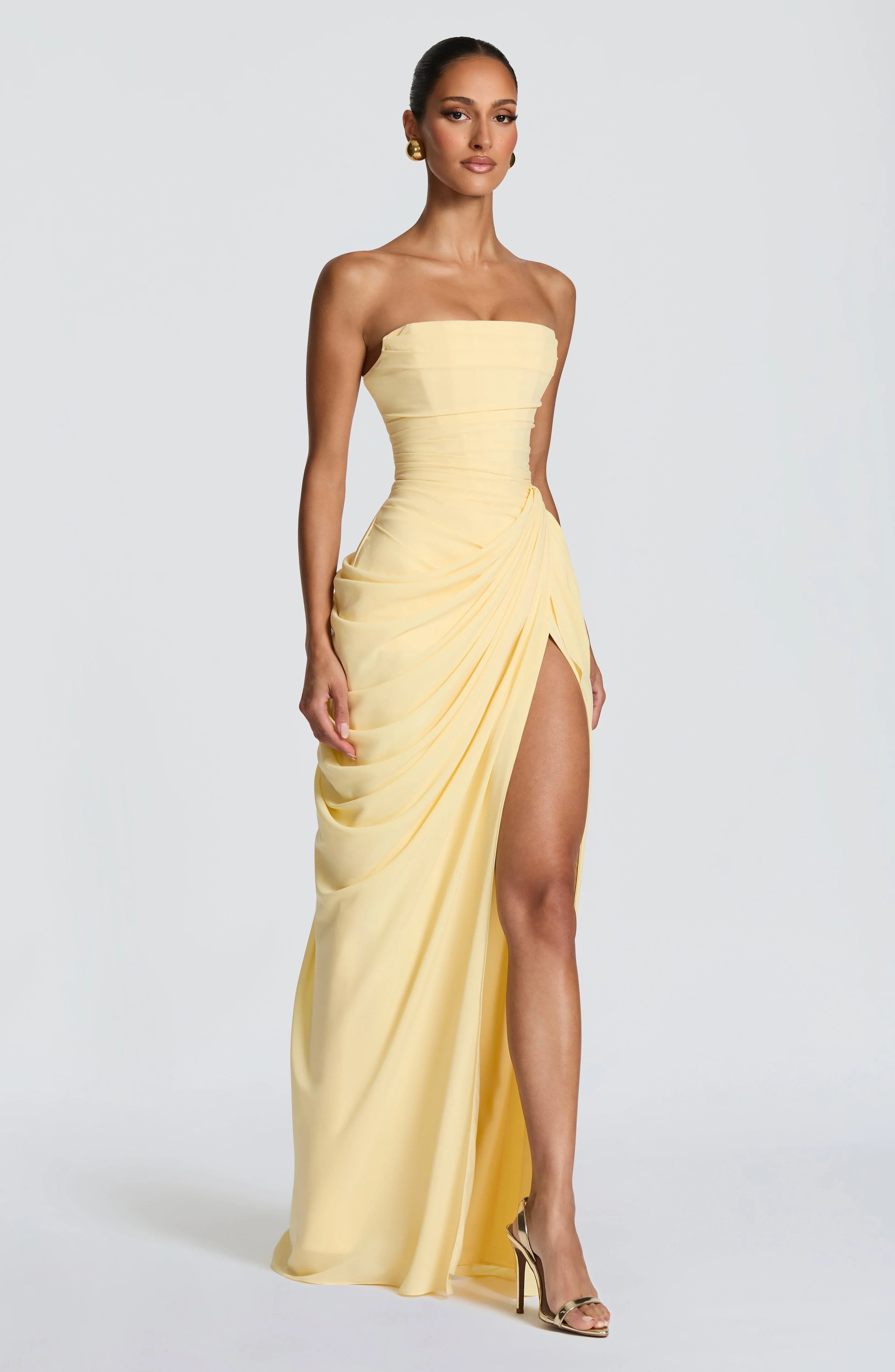 Close-up van asymmetrische heup drapering en zuilrok met soepel vallende stof