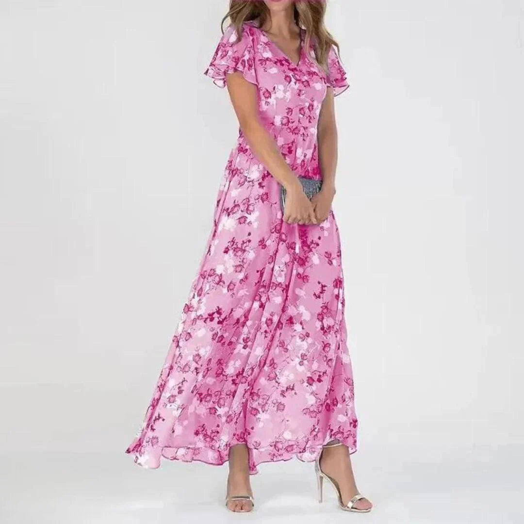 Detail van maxi jurk met bloemenprint, halftransparante vlindermouwen en getailleerde pasvorm voor vrouwelijke uitstraling