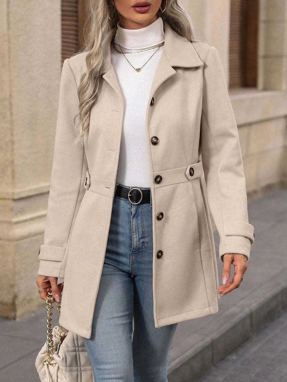 Detail van dubbele knoopsluiting en ceintuur op getailleerde dames trenchcoat voor herfst