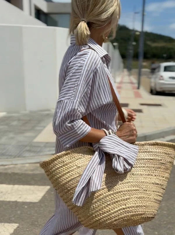 Detail van gestreepte midi blousejurk met oprolbare driekwart mouwen en knoopsluiting