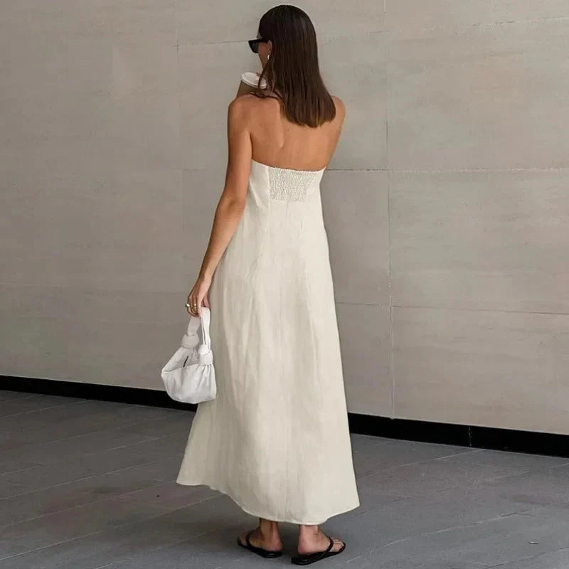 Zijaanzicht van witte strapless maxi jurk met vloeiende stof tot de enkels